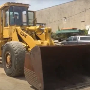 Slightly angled front view of a Cat 966E wheel loader with bucket.