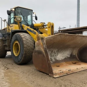 TractorTip Komatsu WA380-5L Loader front corner view showing full tractor with bucket and lights working